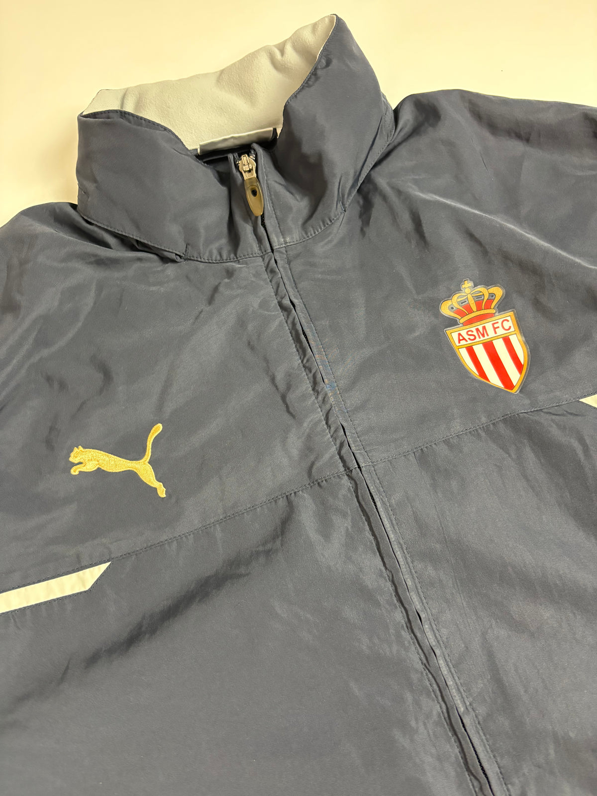 Detail des AS Monaco Clubdetails und Puma Brandings an der schwarzen Vintage Trackjacket