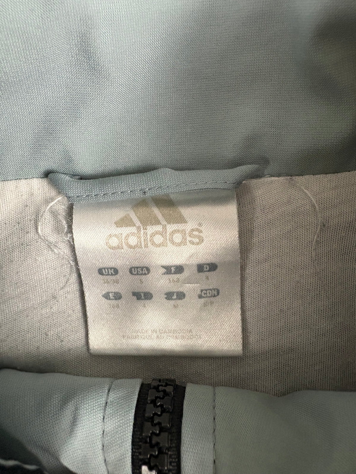 Innenetikett im Kragen der Adidas Trackjacket mit Adidas-Logo und Größenfeld