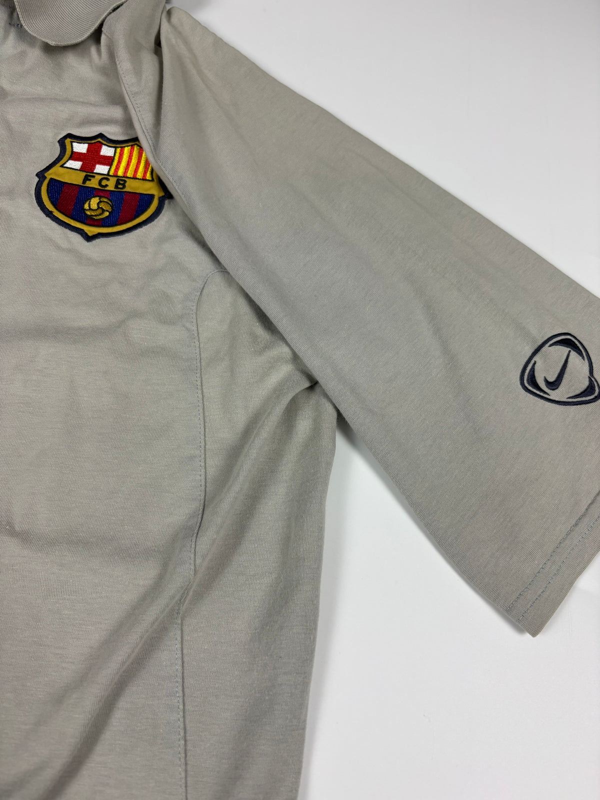 Gesticktes FCB-Wappen mit Kreuz, katalanischen Streifen und Ball auf dem Nike Poloshirt