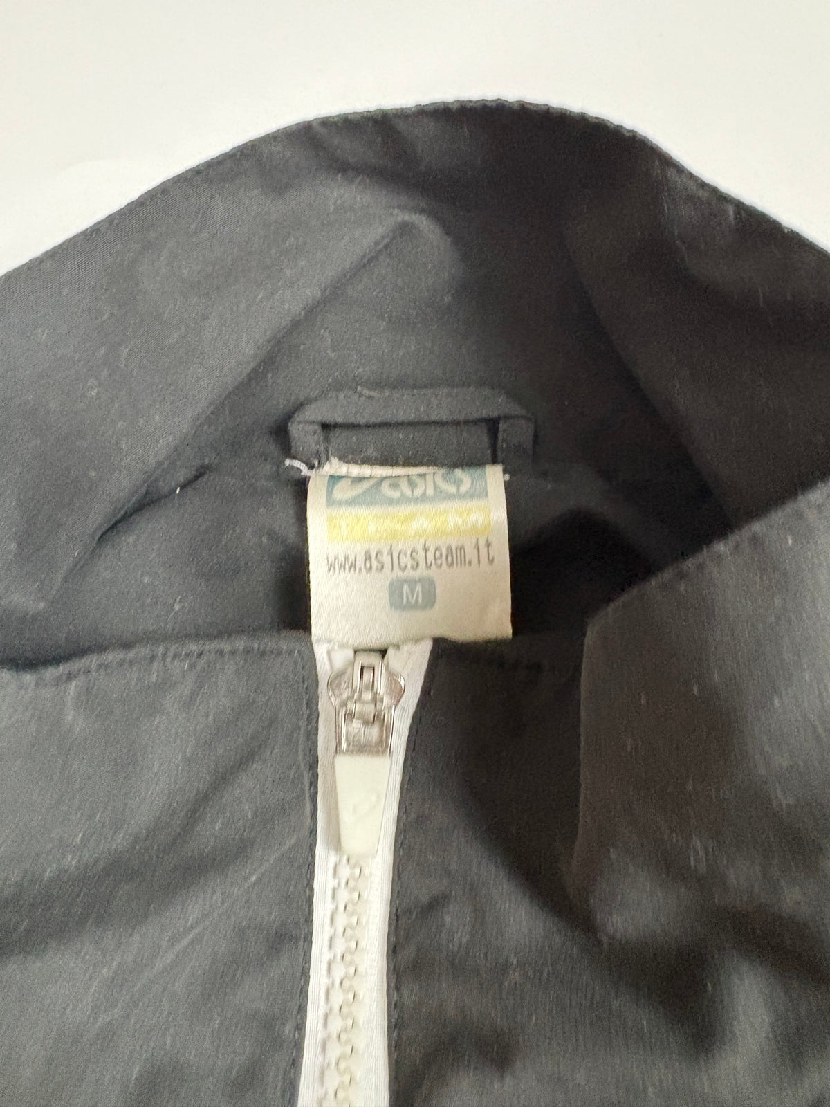 Größenetikett und Big-Logo-Detail der Asics Vintage Trackjacket in Größe M