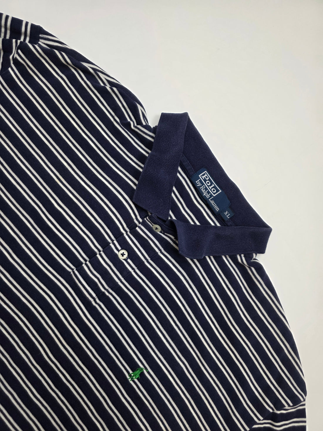 Dunkelblaues Vintage-Poloshirt mit weißen Streifen und gesticktem grünen Logo auf der Brust