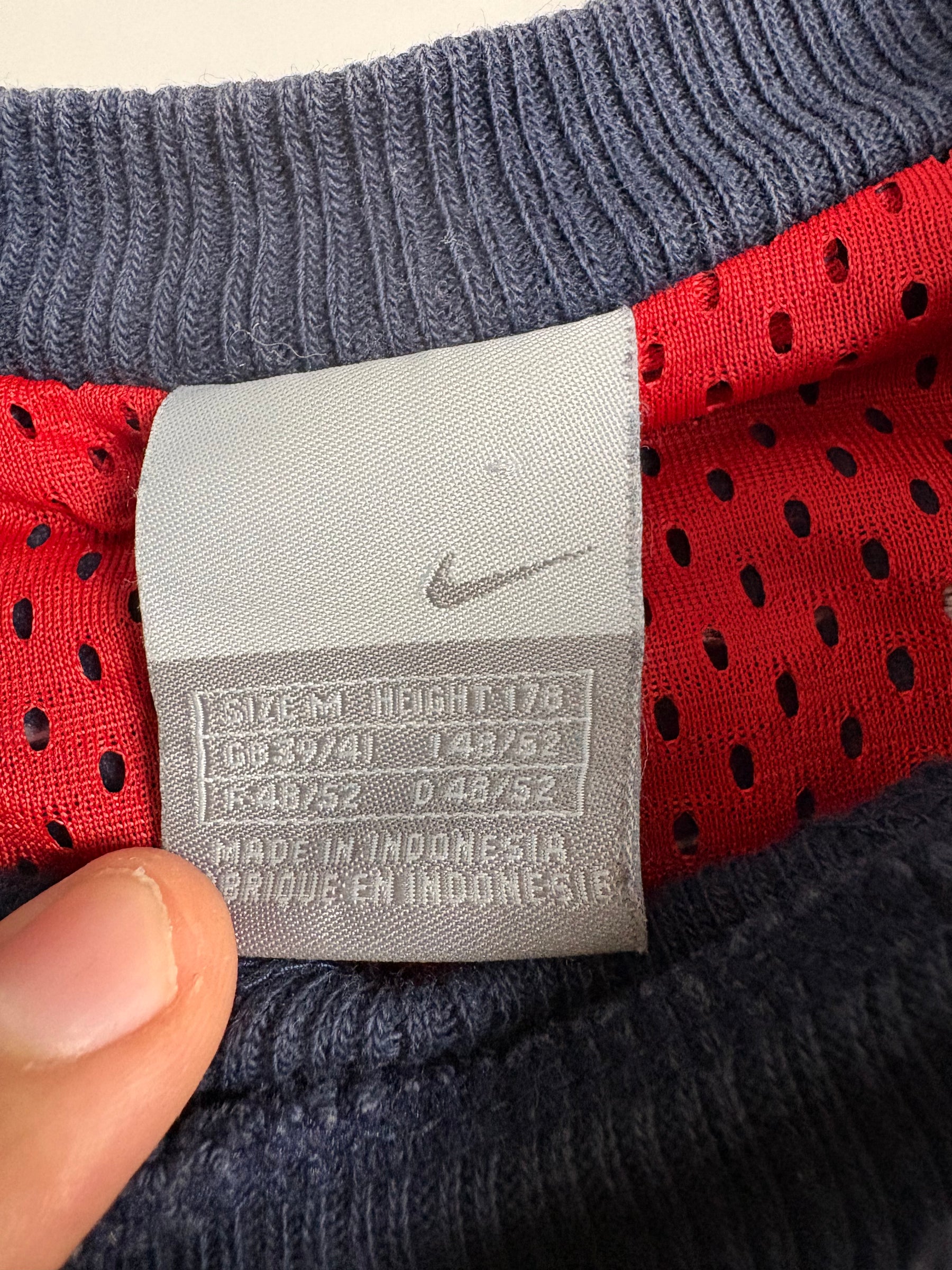 Detailaufnahme des Nike Vintage Sweaters in Navy und Rot