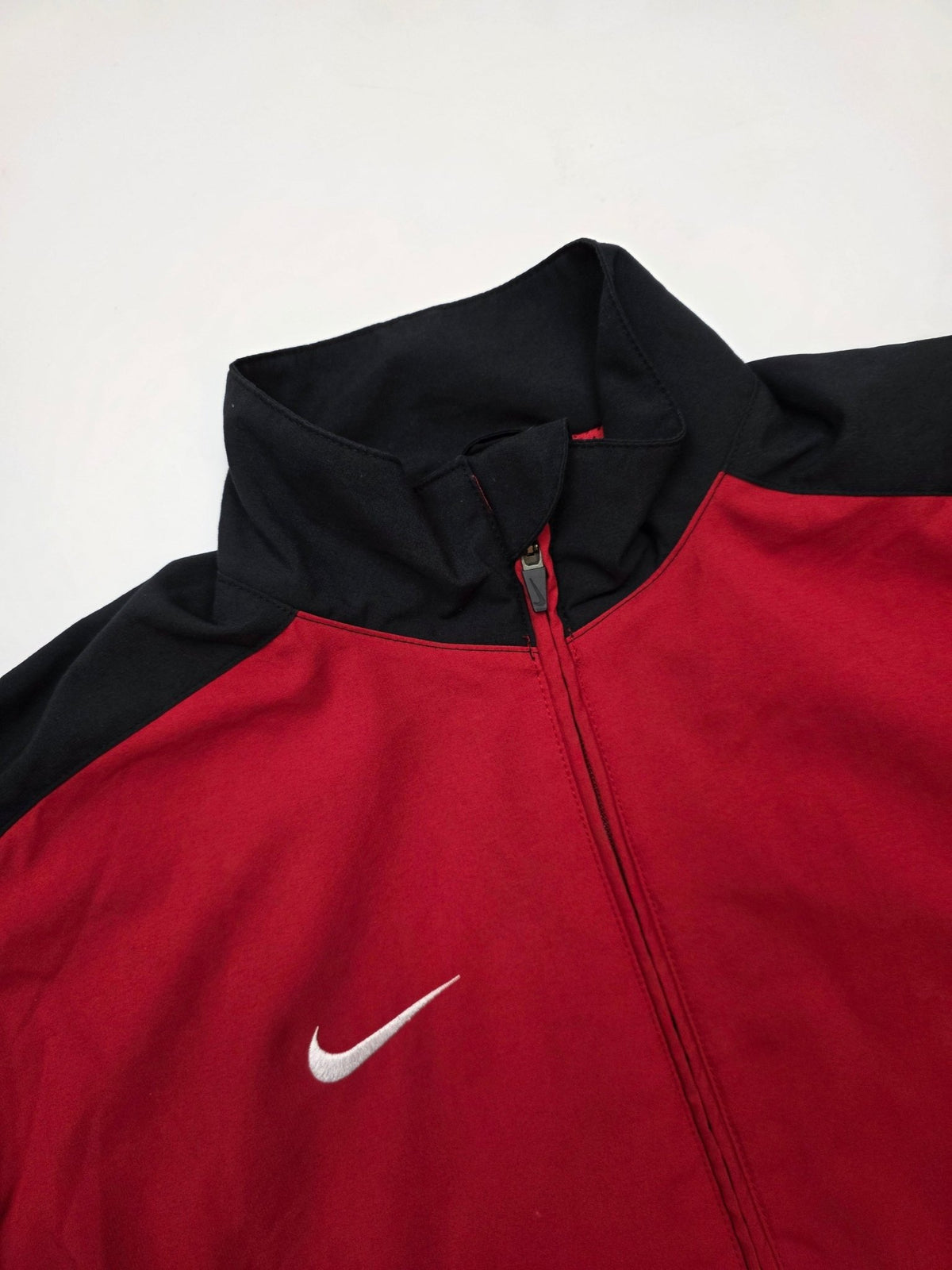 Kleiner weißer Nike Swoosh auf der roten Vintage Trackjacket
