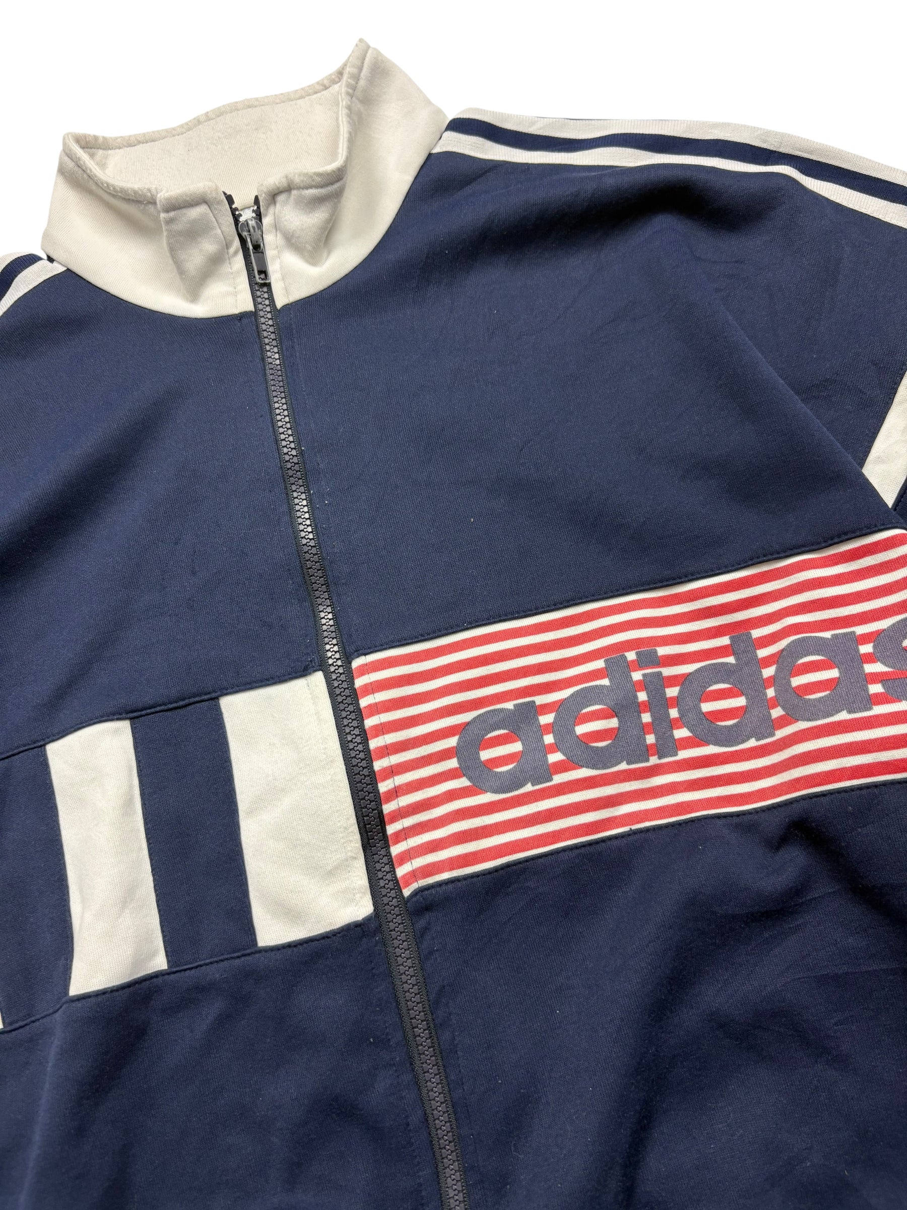 Detail des rot-weiß gestreiften adidas Spellout-Brustpanels an der 90s Vintage Trackjacket