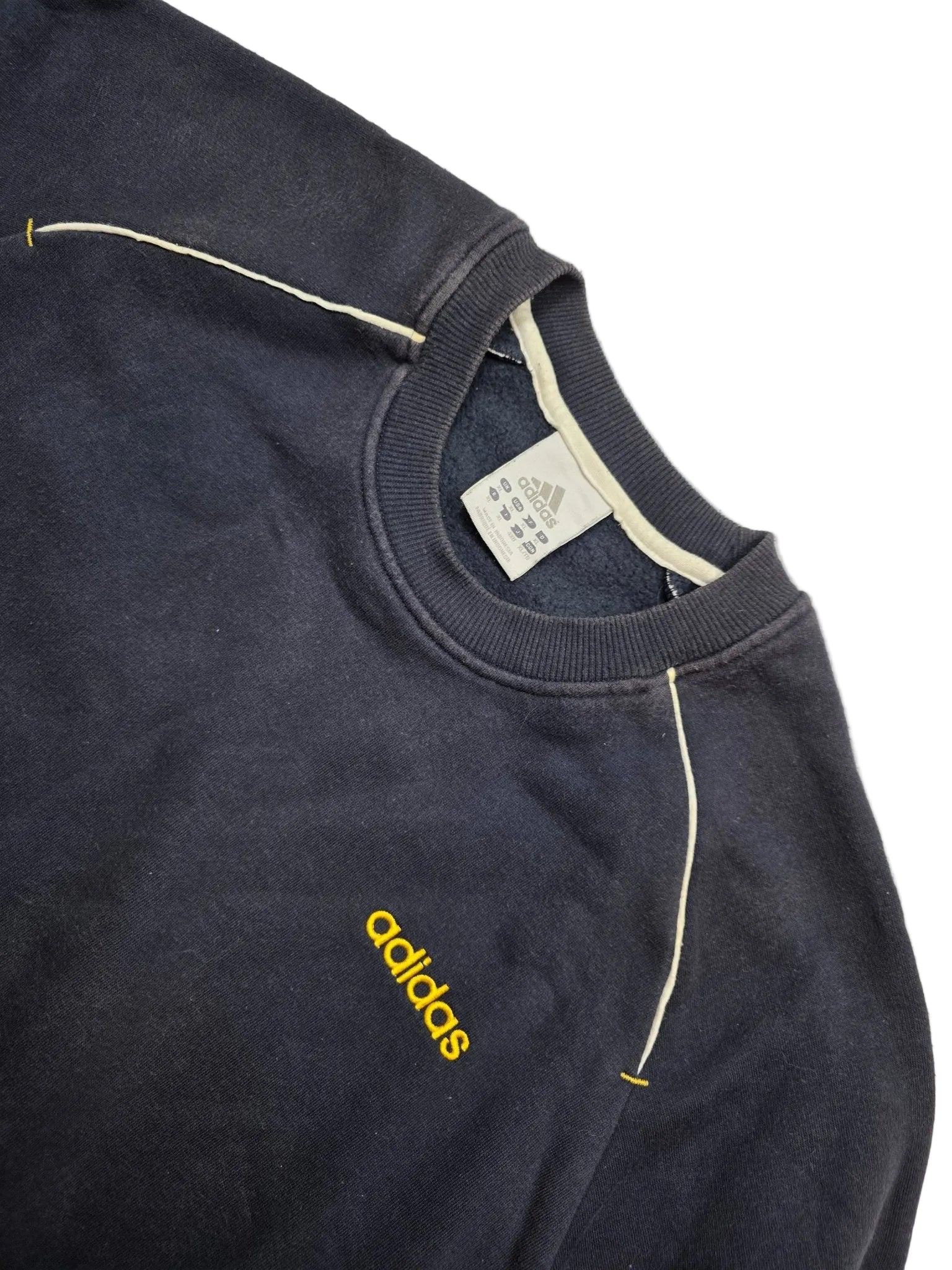 Gelber Adidas Brustschriftzug und Größenetikett am navyfarbenen 90s Vintage Sweater