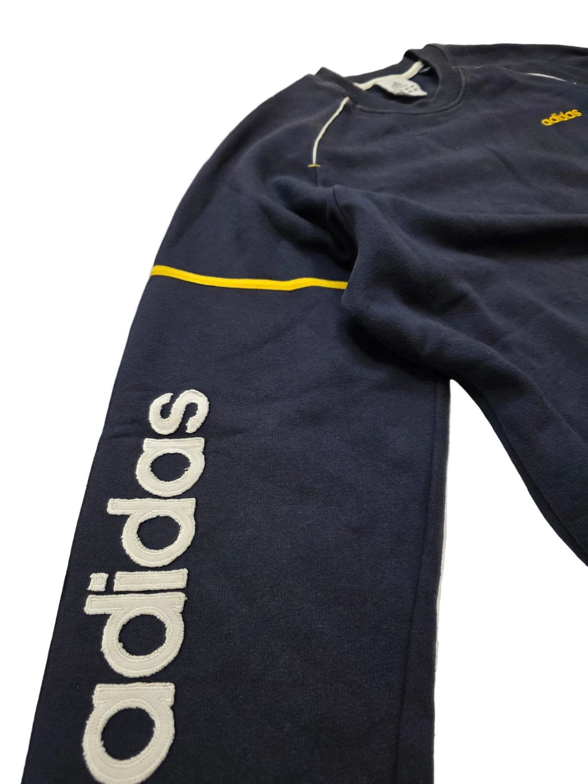 Großes weißes Adidas Ärmellogo und gelbe Streifen am navyfarbenen 90s Vintage Sweater