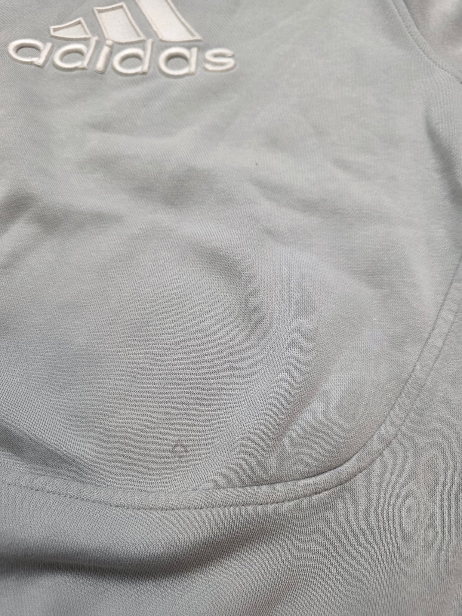 Kleine Gebrauchsstelle auf der Vorderseite des grauen Adidas Vintage Sweaters
