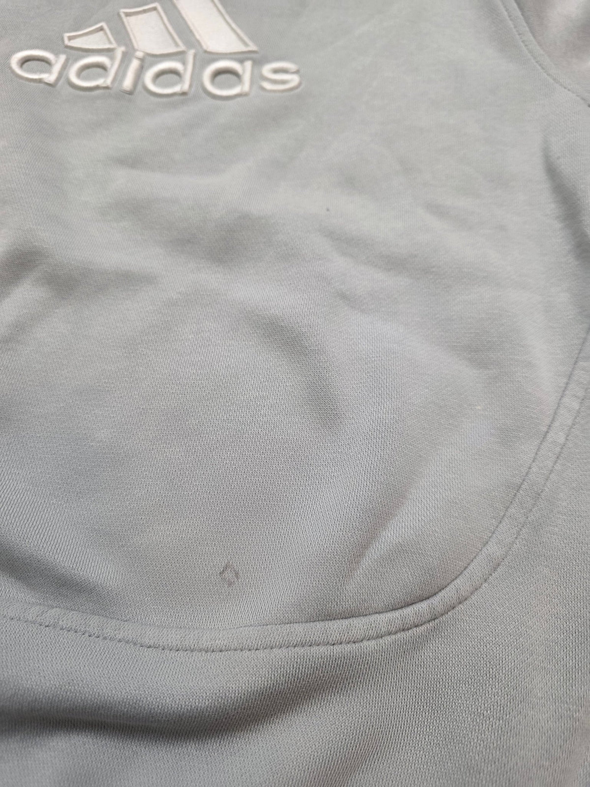 Kleine Gebrauchsstelle auf der Vorderseite des grauen Adidas Vintage Sweaters