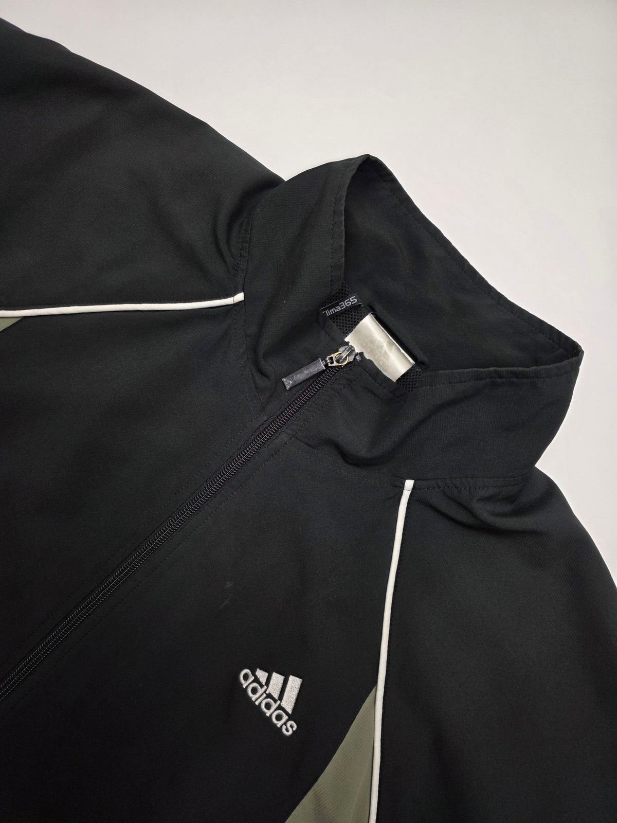 Detail von Adidas Brustlogo, Three Stripes, Stehkragen und Clima365 Kennzeichnung