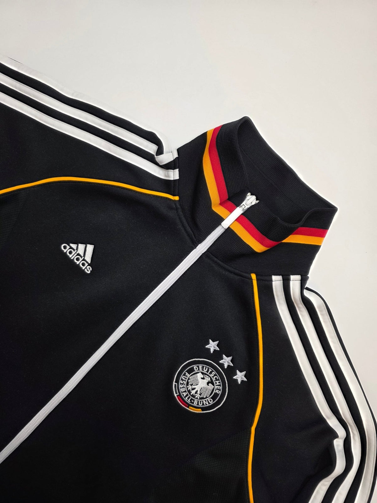 Detail des DFB Drei-Sterne-Wappens, Adidas Logos und der weißen Three Stripes an der Vintage Trackjacket