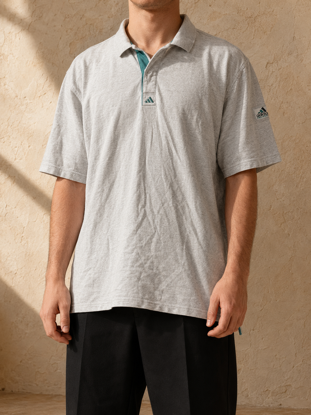 KI-generiertes Tragebeispiel des Adidas Equipment Poloshirts in Hellgrau