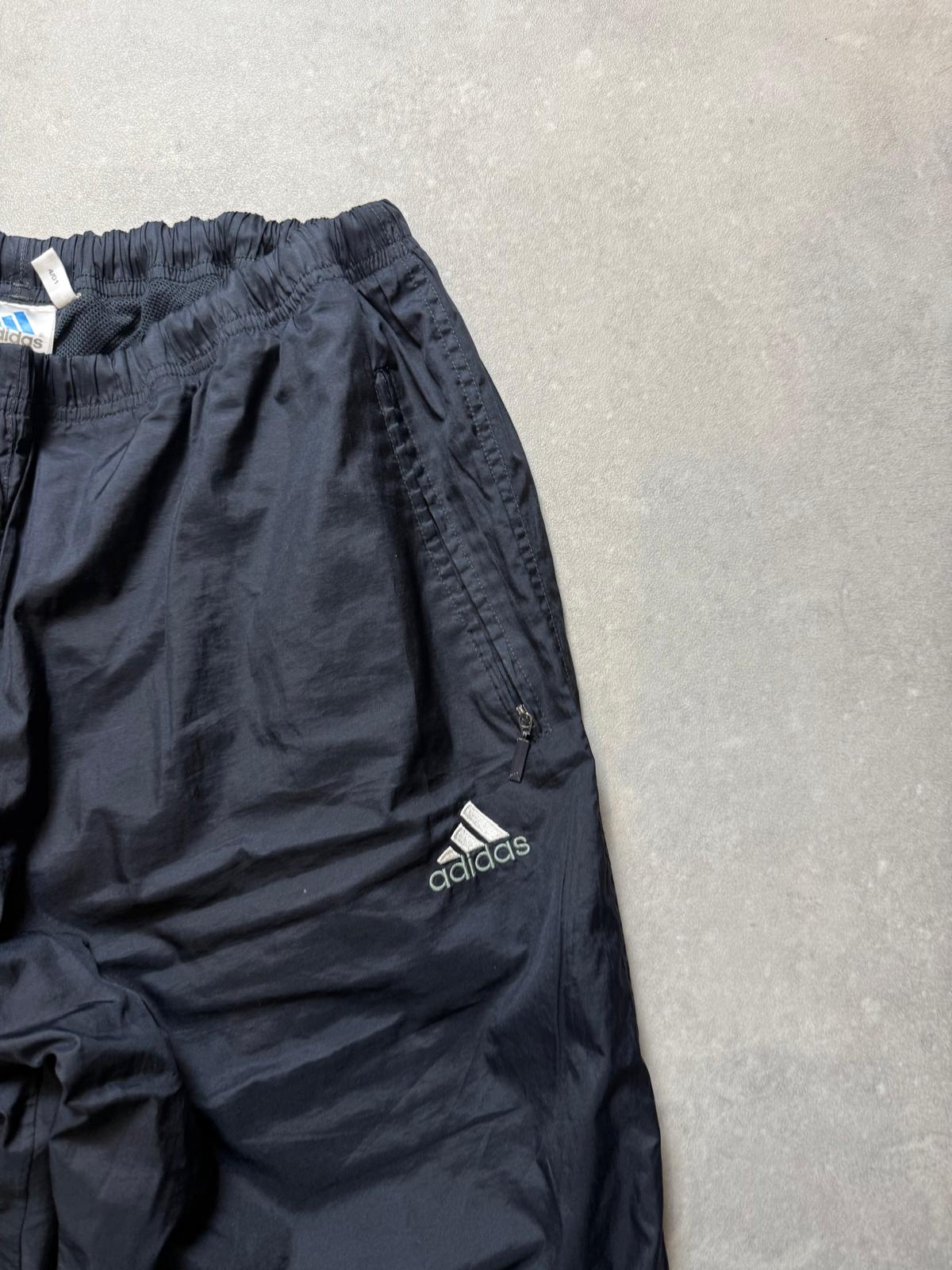 Elastischer Hosenbund, Reißverschlusstasche und Adidas-Logo der Vintage Trackpants