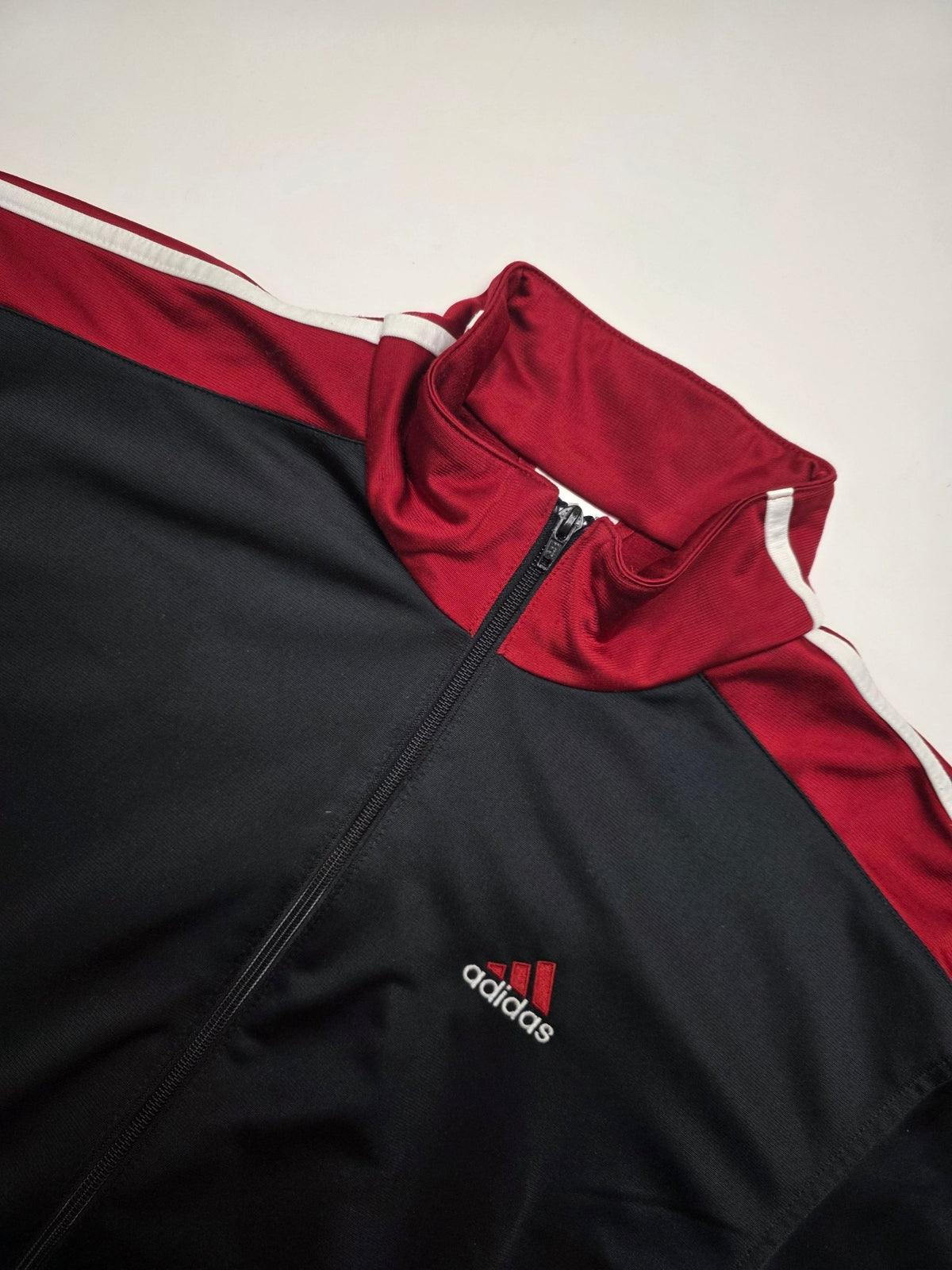 Detail des gestickten Adidas Brustlogos, Stehkragens und Colorblock-Designs der Y2K Trackjacket