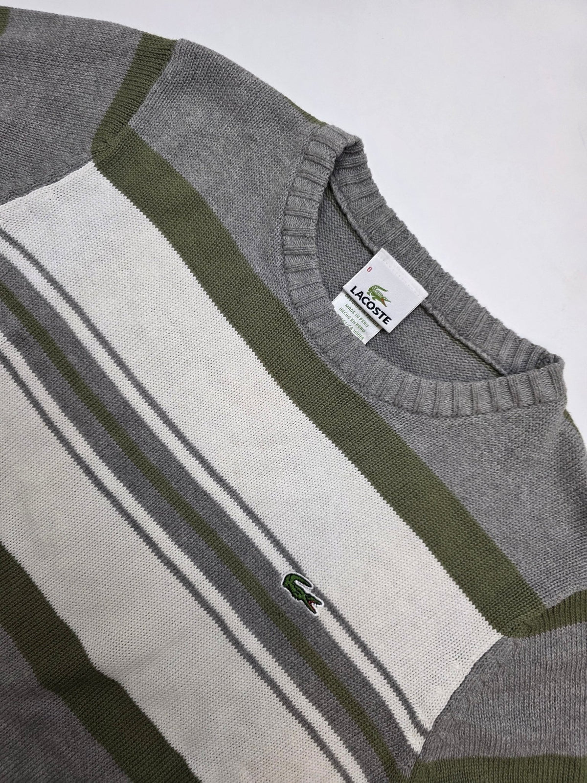 Detail des Krokodil-Logos und Größenetiketts am grauen Lacoste Vintage Strickpullover