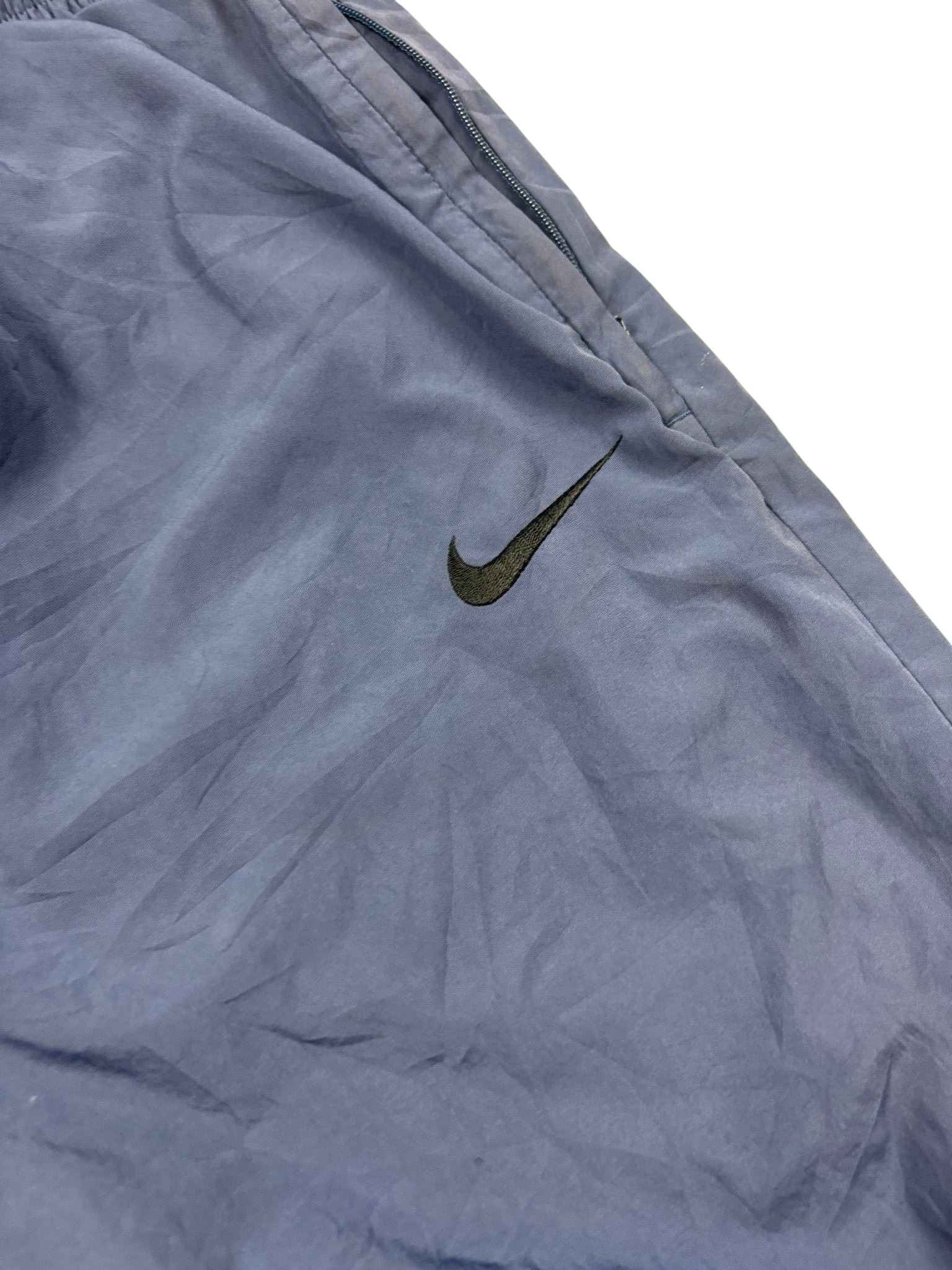 Schwarzer Swoosh auf blauer Nike 90s Trackpants