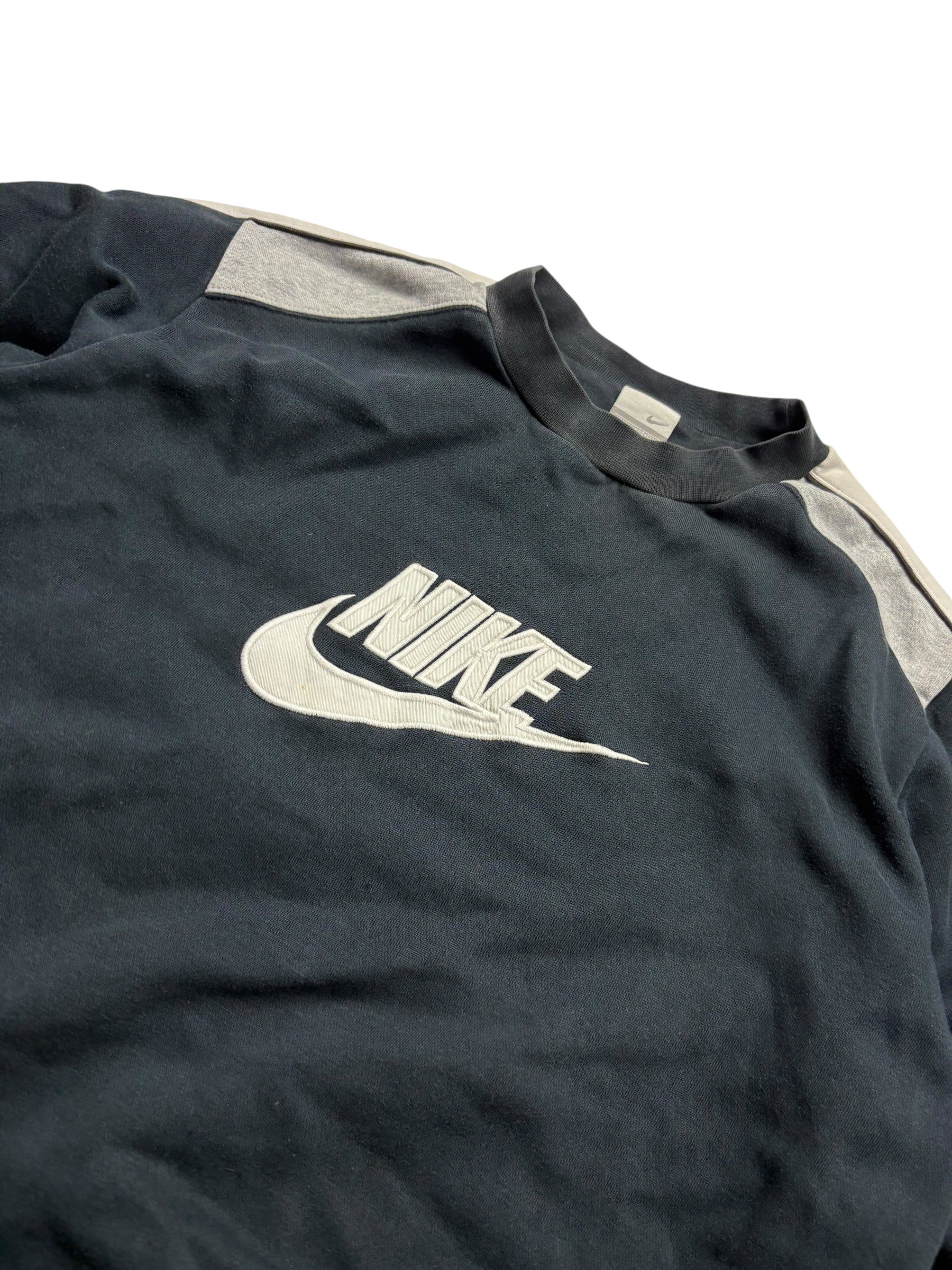 Detail des großen weißen Nike Swoosh Frontlogos am navyfarbenen Vintage Sweater