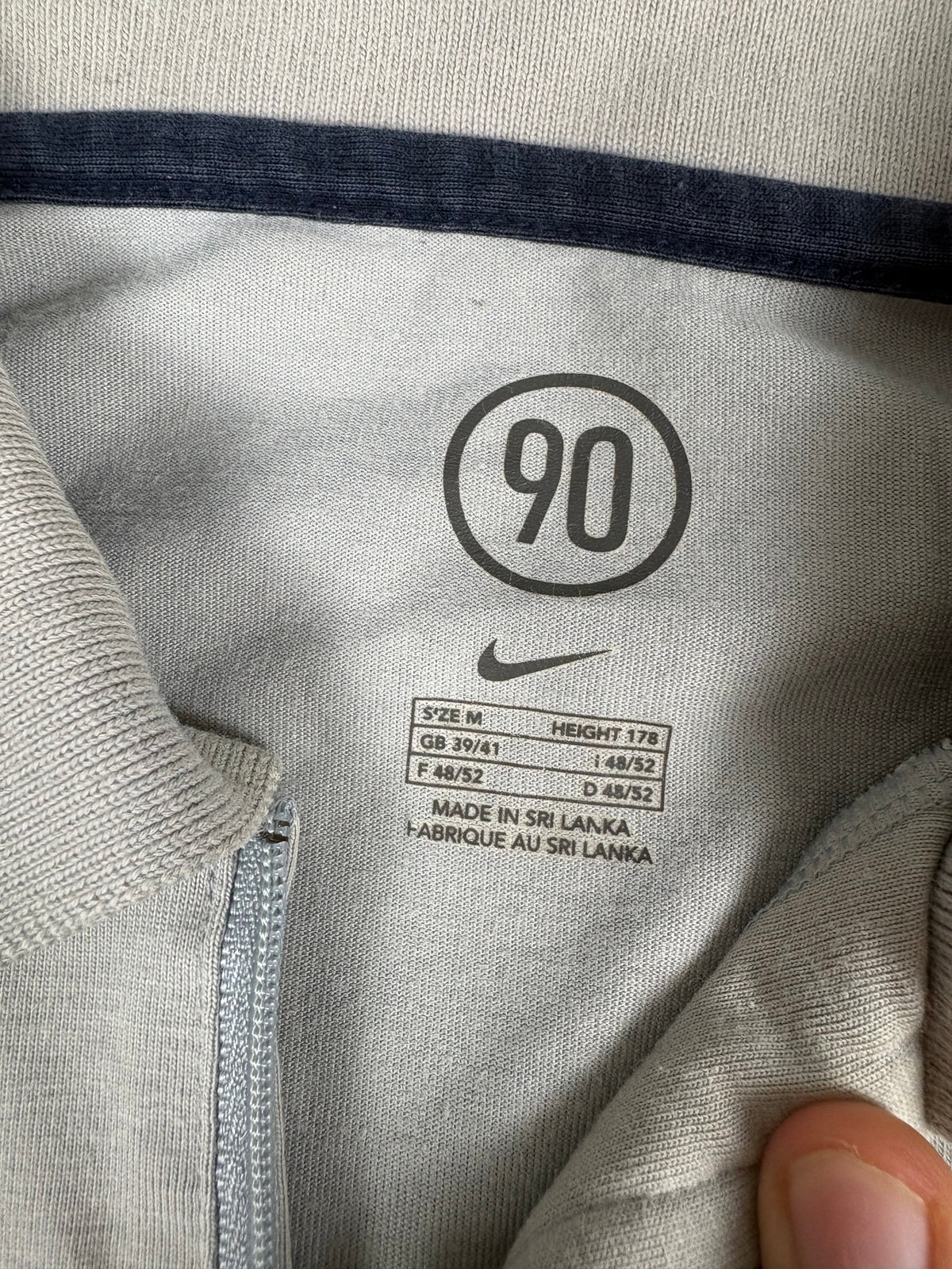 Linker Ärmel mit FCBARCELONA-Stickerei und dunkler Fleck am unteren Saum des Poloshirts