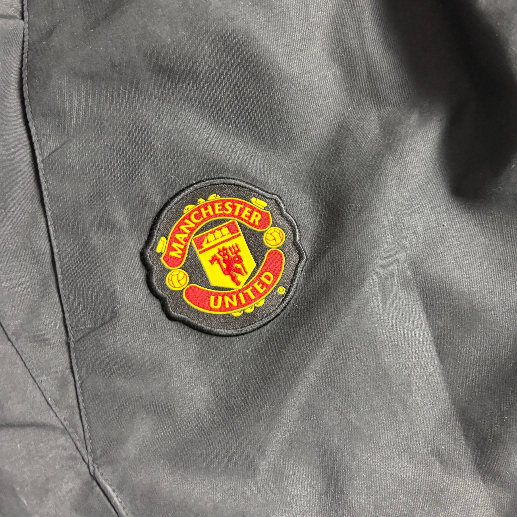Manchester United Wappen auf schwarzer Nike Trackpants