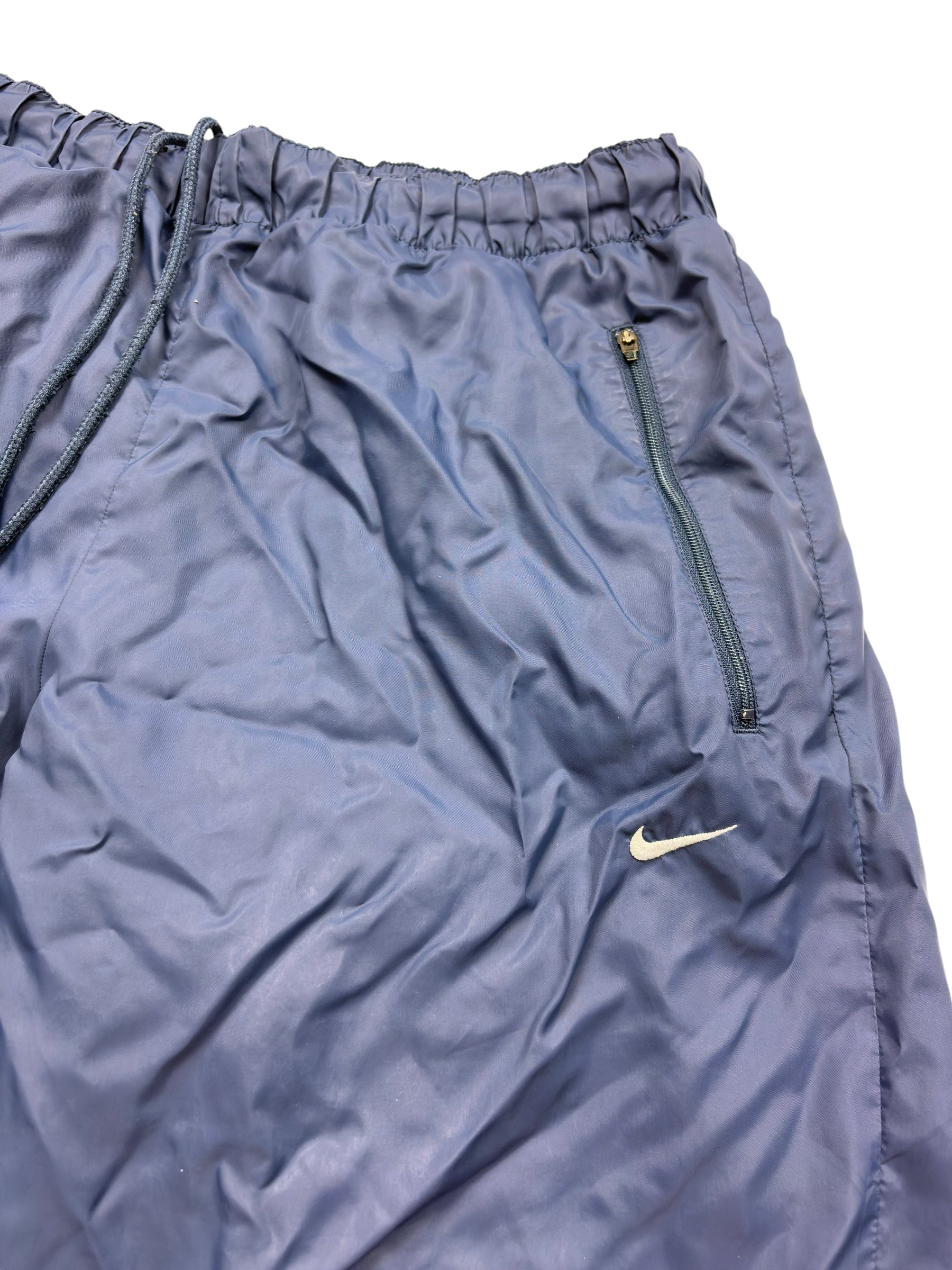 Kleiner weißer Nike Swoosh und Reißverschlusstaschen der dunkelblauen Trackpants