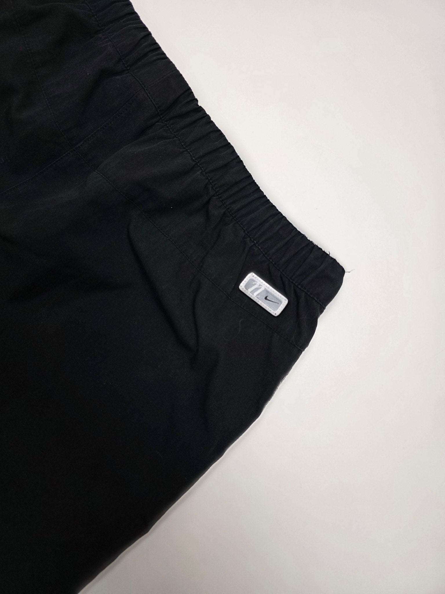 Kleines Nike Logo-Patch am hinteren Bundbereich der schwarzen Vintage Trackpants