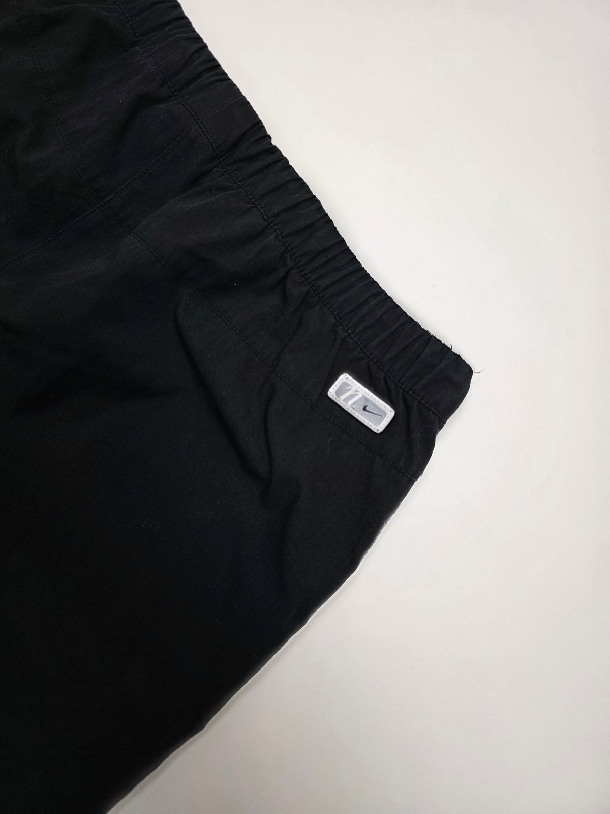 Kleines Nike Logo-Patch am hinteren Bundbereich der schwarzen Vintage Trackpants