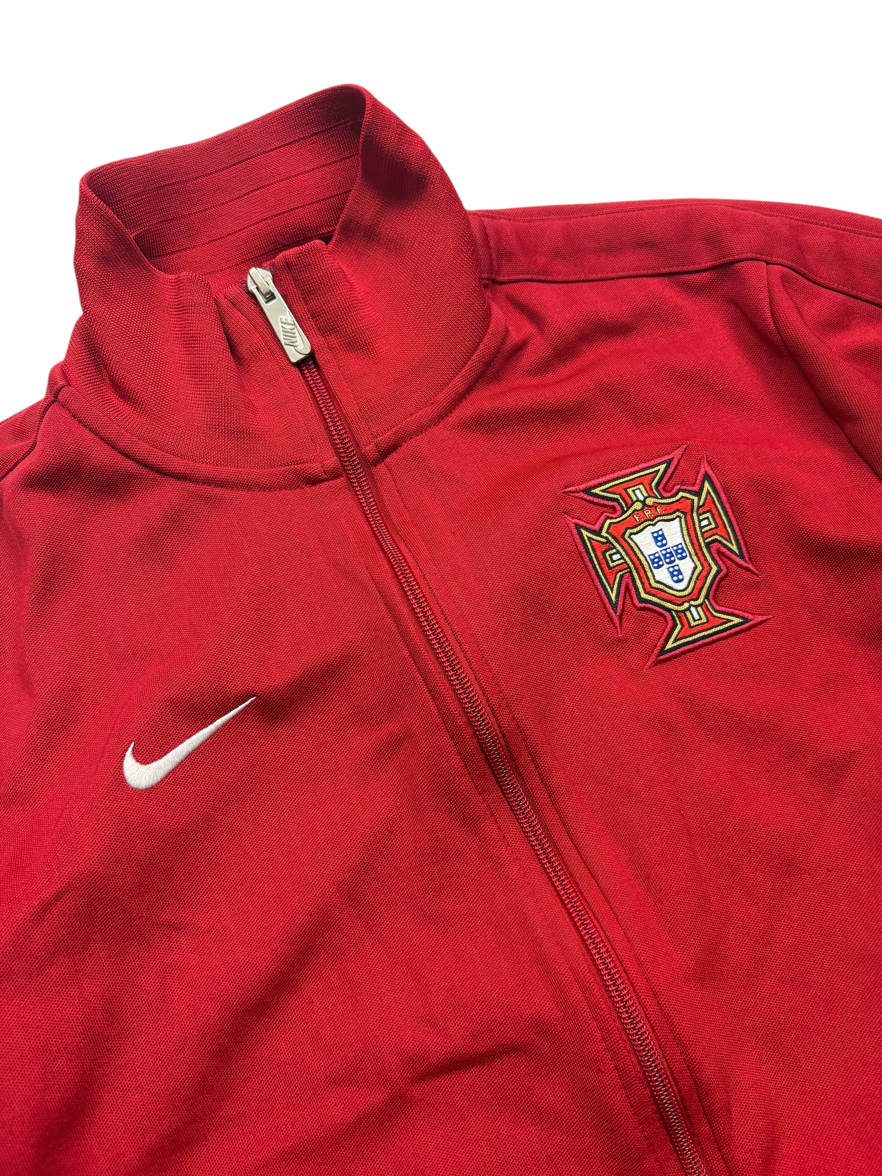 Detail des gestickten Portugal Wappens und weißen Nike Swoosh an der roten Vintage Trackjacket