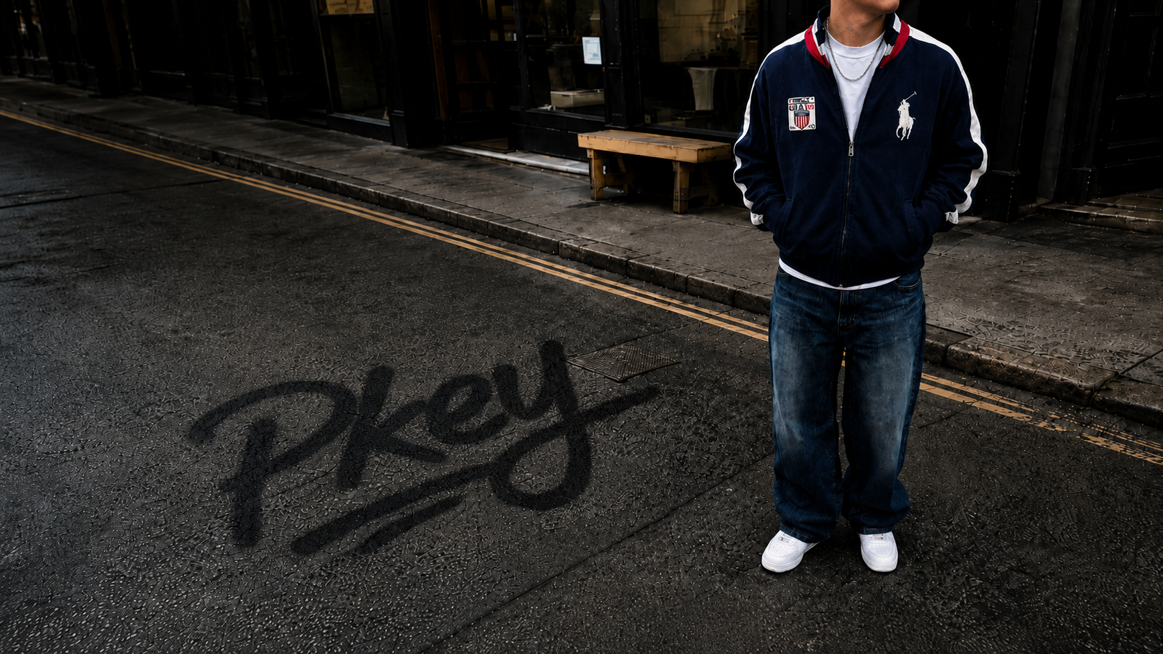 Model mit vintage Ralph Lauren Trackjacket, Jeans und weißen Sneakern auf urbaner Straße