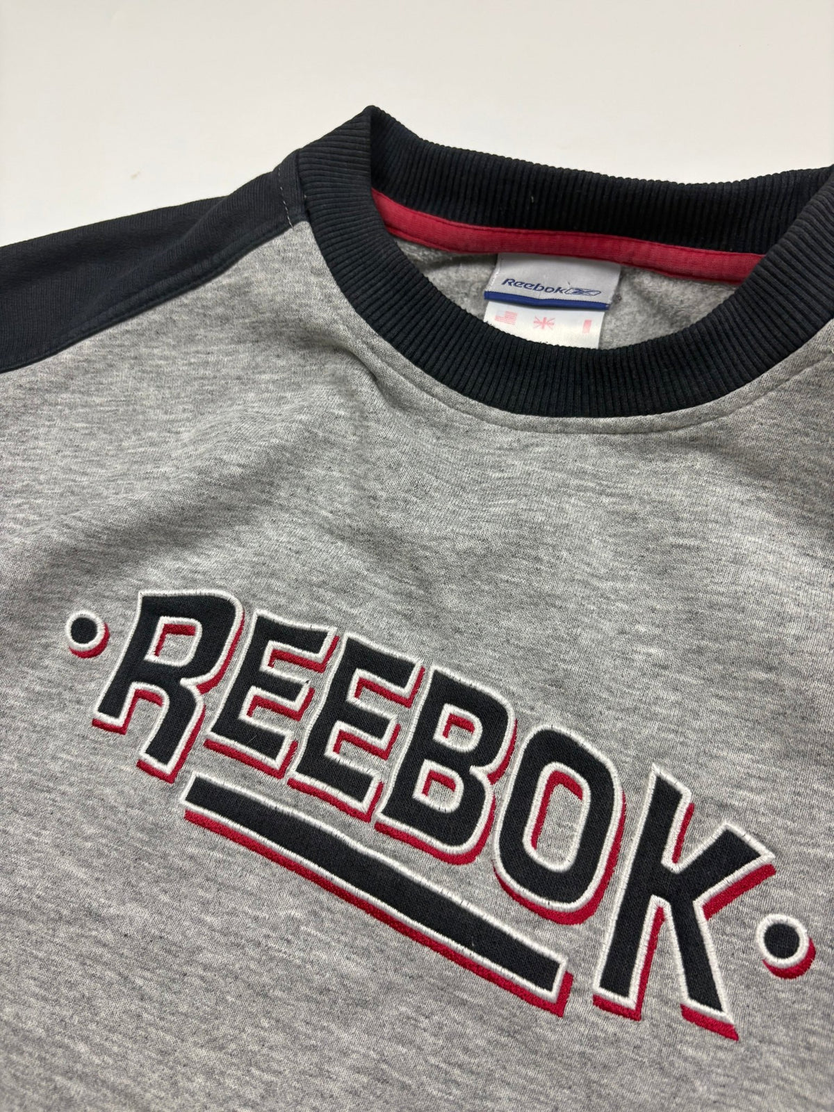 Reebok Spellout 90s Vintage Sweater in Grau/Navy – Logo im Detail