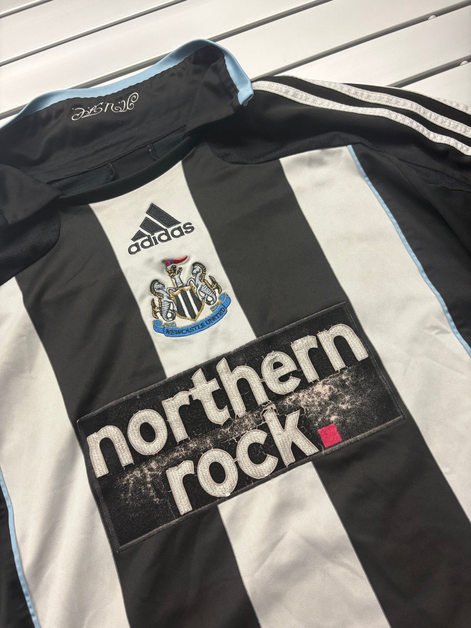 Adidas Newcastle Trikot Brustdetail mit Vereinswappen, Adidas Logo und abgeriebenem Sponsorprint