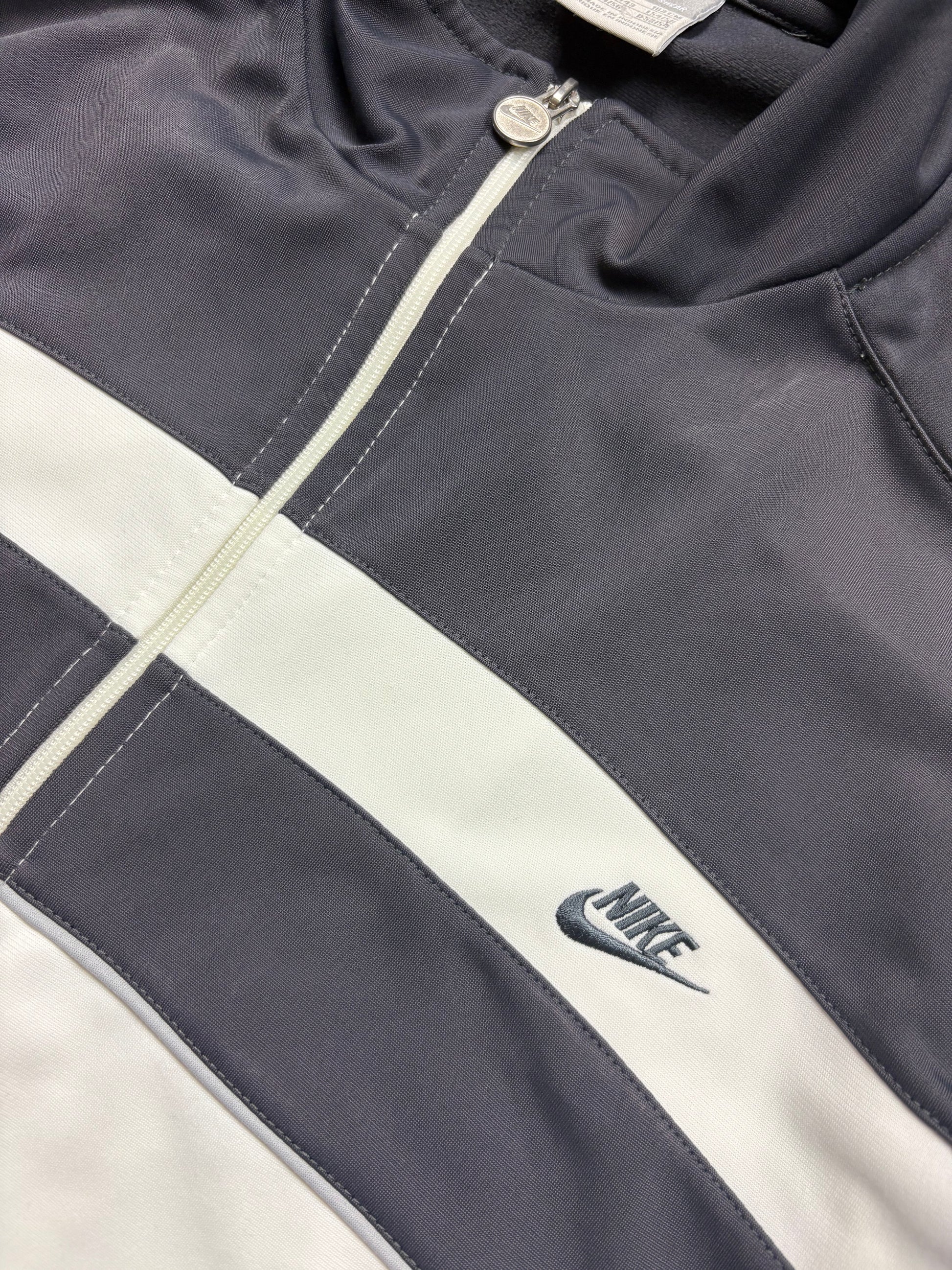 Nike Trackjacket Frontdetail mit kleinem Swoosh, horizontalem Bruststreifen und Nike-Zipper